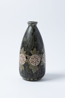 un vase noir orné de fleurs sur fond blanc