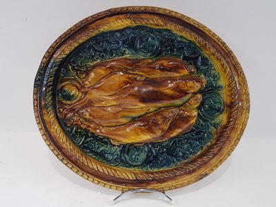 une assiette en céramique ornée d'un oiseau, posée sur un socle