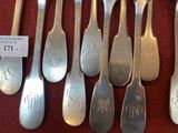 six silver spoons with monograms on them sitting on a table