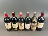 six bottles of wine lined up in a row on a table