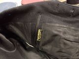 a close up of a black jacket with a yellow tag on it