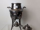 a silver vase sitting on a glass table with a silver lid