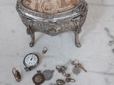 une boîte en argent surmontée d'une horloge, posée sur une table en marbre