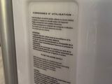 a white refrigerator with a yellow sticker on it