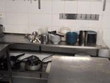 many pots and pans on the counter in this kitchen