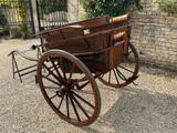 a horse drawn carriage parked in front of a brick wall