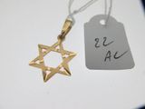 un pendentif en forme d'étoile de David en or, sur lequel est accrochée une étiquette de prix