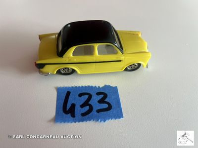 une petite voiture jaune posée à côté d'une feuille de papier bleue