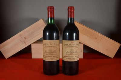 two bottles of red wine sitting next to each other on a table