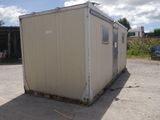 an image of a small building in the middle of a parking lot