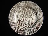 a white plate with black and brown designs on it