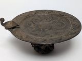 a bronze plate with a bird on top of it