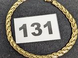 gros plan d'un bracelet en or sur une surface noire