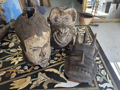 three wooden masks sitting on a table in a room