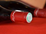 two bottles of wine sitting on a red cloth
