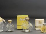 three glass perfume bottles and a box of perfume on a table