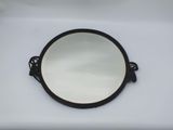 a small mirror on a white table with a black handle
