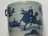 un vase bleu et blanc représentant un homme à cheval