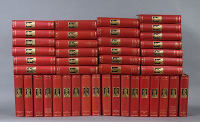 the red books are stacked on top of each other on a gray surface