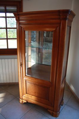 a wooden cabinet with a glass door in a room
