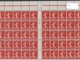 a close up of a red and white envelope with stamps on it
