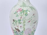 un vase blanc orné d'un oiseau et de fleurs