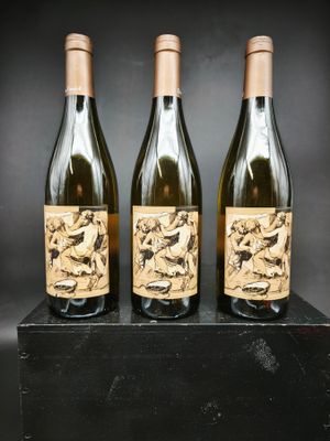 trois bouteilles de vin posées sur un bloc de bois