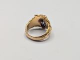 a close up of a gold ring with a red stone in the middle