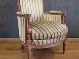 une vieille chaise dont l'assise est recouverte d'un tissu rayé