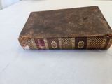 an old book sitting on top of a white table next to a window