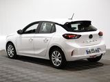 the back end of a white car in a room with a checkered floor