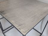 the table is made of metal and has a concrete top