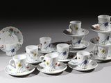 un grand nombre de tasses et de soucoupes sur une table