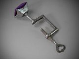 a metal clamp with a purple handle on a table
