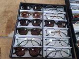 many pairs of glasses sitting in a box on the floor