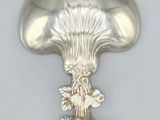a silver spoon with a mushroom on it on a table