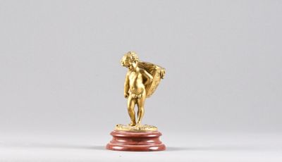 a gold statue of a man on a red pedestal