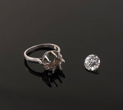 a close up of a diamond and a ring on a black surface