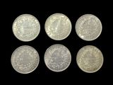 six different british coins on a black background