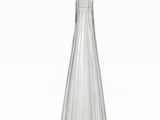 une bouteille en verre transparent au goulot effilé, posée sur une surface blanche