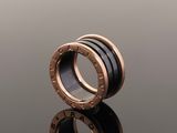 a black and rose gold ring on a reflective surface