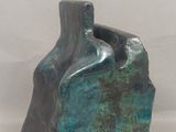 un petit vase bleu posé sur une table blanche