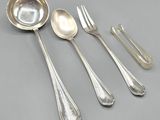 a set of five silver spoons and two silver spoons on a gray surface