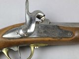 an old gun with a wooden handle on a white surface