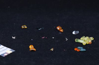 a close up of a bunch of small pieces of glass on a black surface