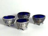 trois bols en verre argenté et bleu posés sur une surface blanche
