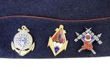 several badges are placed on top of a hat on a white surface