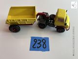 un camion jaune et un camion-benne jaune posés sur une table blanche