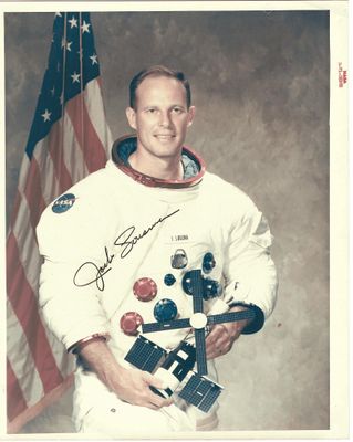 une vieille photo d'un homme en combinaison d'astronaute tenant un drapeau américain