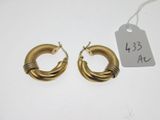 two pairs of gold hoop earrings on a white surface
